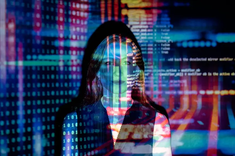 A woman's portrait overlaid with projected lines of code and streams of binary digits.