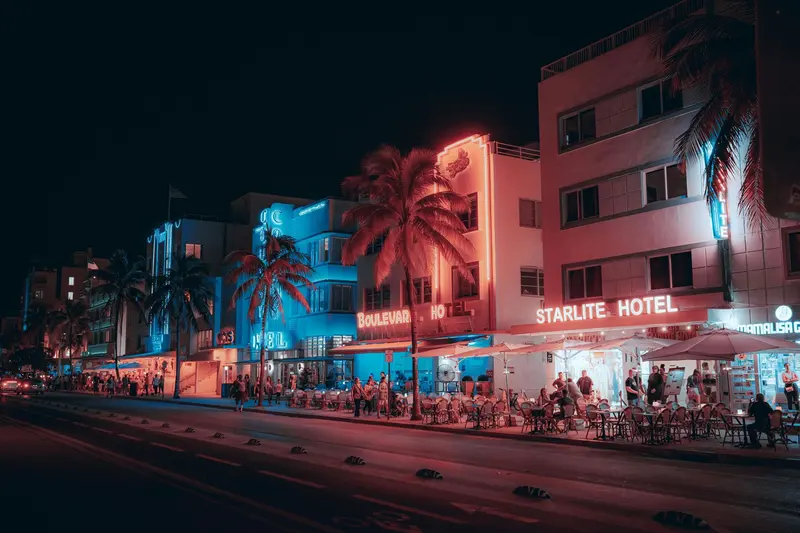 A row of buildings are lit up at night in a city.